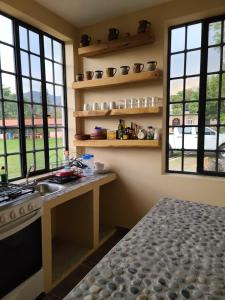 uma cozinha com um lavatório, um fogão e janelas em Departamentos Vista Nueva Malinalco em Malinalco