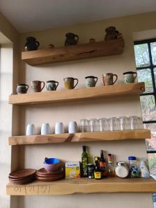 a shelf with pots and pans and other items on it at Departamentos Vista Nueva Malinalco in Malinalco