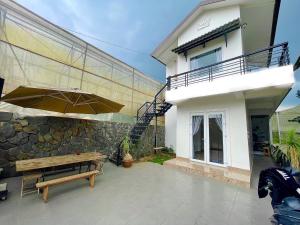 een patio met een houten bank en een gebouw bij ViVu House 2 in Da Thien