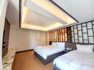 a hotel room with two beds and a skylight at CHORLADA LANNA HOTEL in Chiang Mai