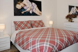 a bedroom with a red and white bed and two lamps at Costa e Mare in Savona