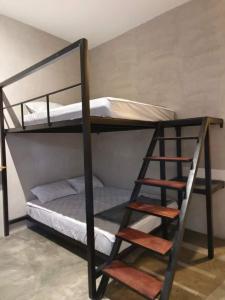 a couple of bunk beds with a ladder in a room at EUC Room Stay in Tuaran