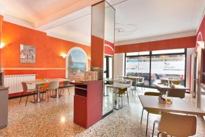 a restaurant with tables and chairs and windows at Hotel Calypso in Ventimiglia +28 photos