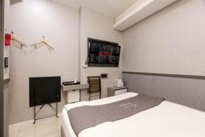 ソウルにあるHotel dongyangjang Dongdaemun-Jongnoのベッドルーム(ベッド1台、テレビ付)