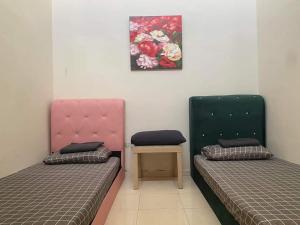 two beds sitting next to each other in a room at Nice and cozy house in Muar in Muar