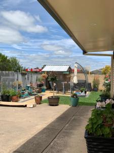 a patio with potted plants and a playground at Cowra Crest Motel in Cowra