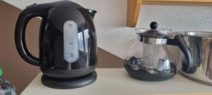 a black appliance sitting on a counter next to a blender at Chambre d'Hôtes R&S in Bemont