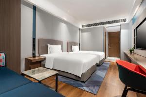 um quarto de hotel com uma cama e um sofá em Holiday Inn Express Nanning Convention&Exhibition em Nanning