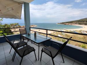 un tavolo e sedie su un balcone con vista sulla spiaggia di Maries sea view house a Skala Marion