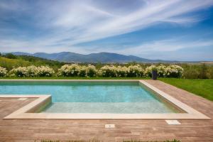 a swimming pool in the middle of a yard with trees at Podere n.8 Bio Casale Maremma in Alberese
