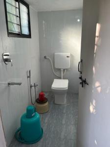 a bathroom with a white toilet and a window at Hotel Tathastu in Rāmtek