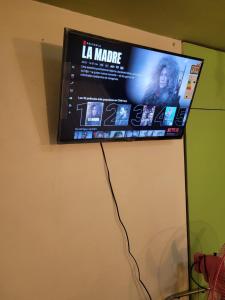 TV de pantalla plana colgada en la pared en Económicas y Cómodas Habitaciones Privadas cerca de Playa, en Arica