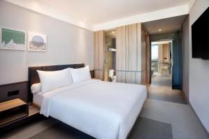 a bedroom with a large white bed and a balcony at ibis Yogyakarta International Airport Kulon Progo in Yogyakarta
