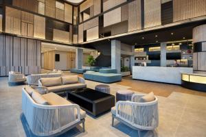 a lobby with couches and chairs in a building at ibis Yogyakarta International Airport Kulon Progo in Yogyakarta