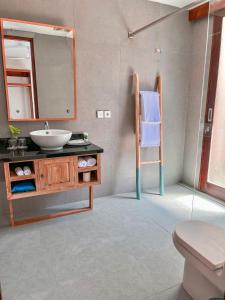 a bathroom with a sink and a mirror at Taj Maza Sunset Villas in Gili Trawangan