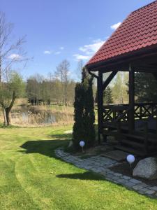 a wooden gazebo with mushrooms on the grass at Agroturystyka Giże - domek letni in Ełk +4 photos