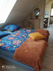1 dormitorio con 1 cama con edredón azul en Agroturystyka Giże - domek letni en Ełk
