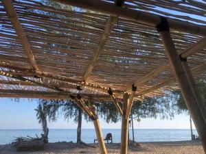 a wooden pavilion on the beach near the water at La Bohème in Gili Air