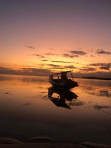 a boat sitting on the beach at sunset at La Bohème in Gili Air