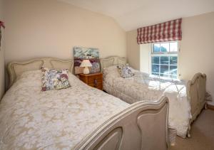 a bedroom with two beds and a window at Glan Merion in Llanbedrog