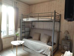 ル・モンドールにあるAppartement chaleureux et cosyのベッドルーム1室(二段ベッド2組、テーブル付)