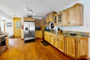 a kitchen with wooden cabinets and a stainless steel refrigerator at Pine Lantern Retreat in South Lake Tahoe