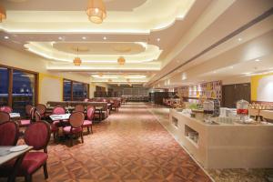a restaurant with tables and chairs and a bar at Regenta Central City Vilas Palace Ambala in Ambāla