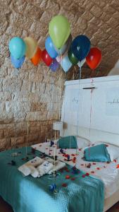 a bunch of balloons are hanging above a bed at Le Blanc Bleu in Jbeil