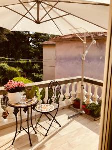 een tafel en stoelen op een balkon met een parasol bij Appartamento vista Rocca in Sala Baganza