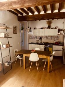 kuchnia z drewnianym stołem i białymi krzesłami w obiekcie Appartamento vista Rocca w mieście Sala Baganza