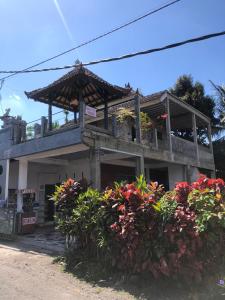 ein Gebäude mit einem Balkon mit Blumen davor in der Unterkunft Buana Asti Homestay in Tabanan