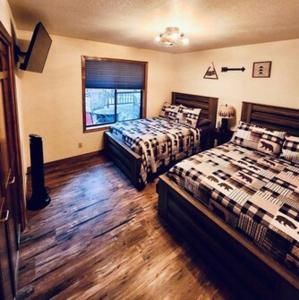 a bedroom with two beds and a window at Cheerful Kathys Cabin, King Bed, Hot Tub, Close to NAU, Airport & Hiking Trails! in Flagstaff