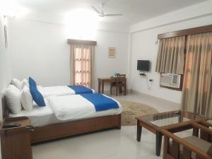 a bedroom with a bed and a table in it at The Camellia in Dibrugarh