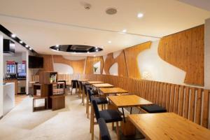 un restaurante con paredes de madera, mesas y sillas de madera en R's Forest Inn, en Kawasaki