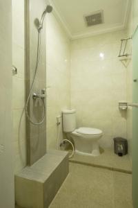 a bathroom with a toilet and a shower in it at Frangipani Homestay in Nusa Dua