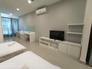 a room with two beds and a flat screen tv at Peace home09 in Cyberjaya