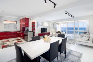 a kitchen and living room with a white table and chairs at Scarborough Waterfront Penthouse Unit in Scarborough