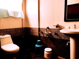 een badkamer met een toilet en een wastafel bij Yuvraj Galaxy Inn in Mysore