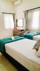 1 dormitorio con 2 camas en una habitación en Surokarsan 9 House Yogyakarta en Yogyakarta