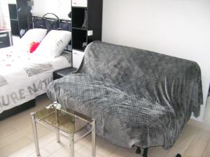 a couch sitting in a room with a bed at Charmant STUDIO au Calme Tout Confort Dans Château Néo Gothique proche ZENITH COMET ORLEANS Parking Voiture Gratuit WIFI Haut Débit Rue des Montées in Orléans +48 photos