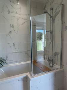 a bathroom with a shower with a glass door at Machynys Peninsula Home-Beach/Golf/Cycle- Llanelli in Llanelli