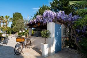 a bike parked next to a building with purple wisteria at Hôtel Beau Site - Cap d'Antibes in Antibes