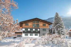 a house in the snow with snow covered trees at Apartment in Bramberg am Wildkogel with terrace in Bramberg am Wildkogel