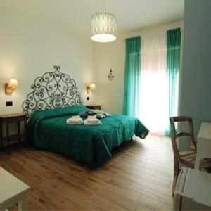 a bedroom with a green bed and a table and chairs at OLTREMARE in Scalea