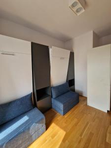 um quarto com duas cadeiras azuis num quarto em Messe München Smartapart em Munique