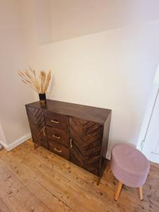 una cómoda de madera y un taburete en una habitación en Casa Lucia, en Knittelfeld