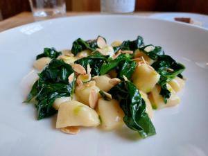 un plato blanco con un plato de pasta con espinacas en Castel Pergine en Pergine Valsugana