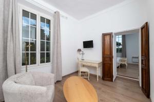 a living room with a desk and a chair at Hôtel Beau Site - Cap d'Antibes in Antibes