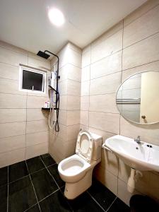 ein Badezimmer mit einem WC, einem Waschbecken und einem Spiegel in der Unterkunft The Heim in Kajang