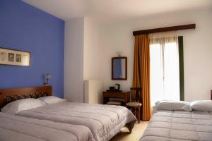 1 dormitorio con 2 camas y ventana en Artemis Hotel, en Delfos